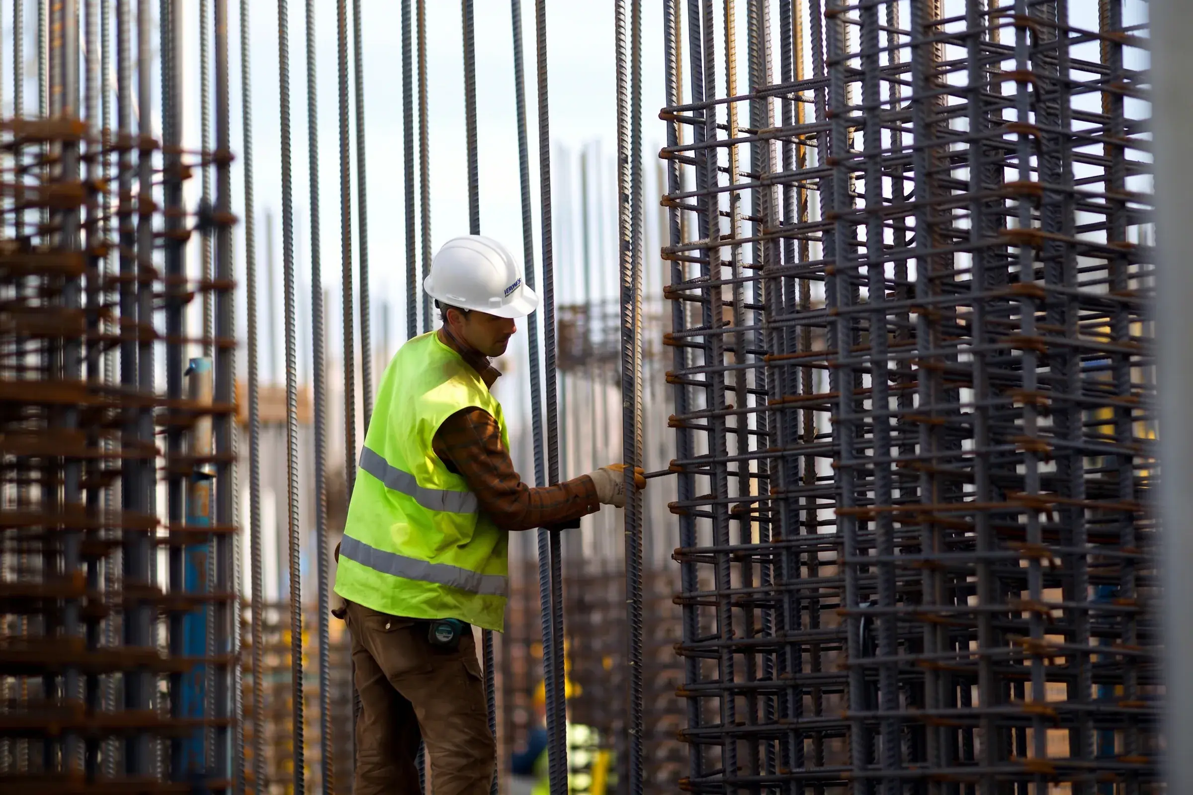 Obrero de Grupo Verones armando el acero de una columna en obra